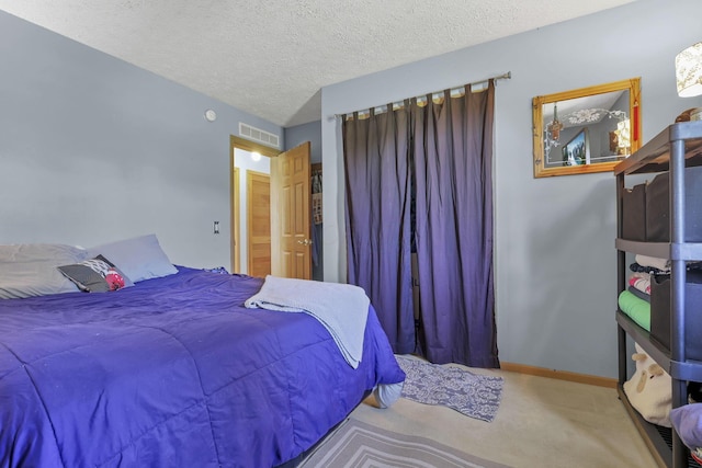 carpeted bedroom with a textured ceiling, visible vents, and baseboards