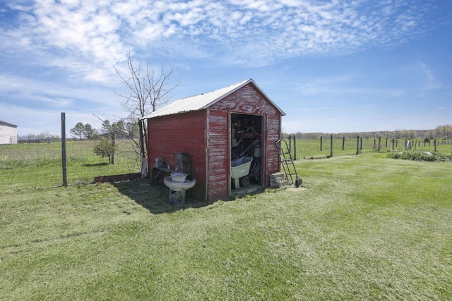 view of shed featuring fence and a rural view