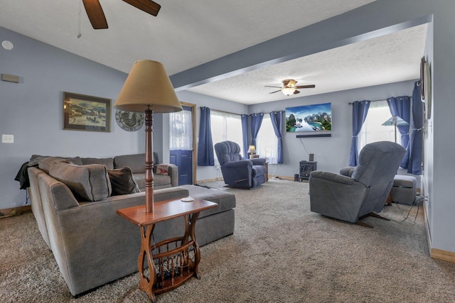 living area with carpet flooring, a textured ceiling, ceiling fan, and baseboards