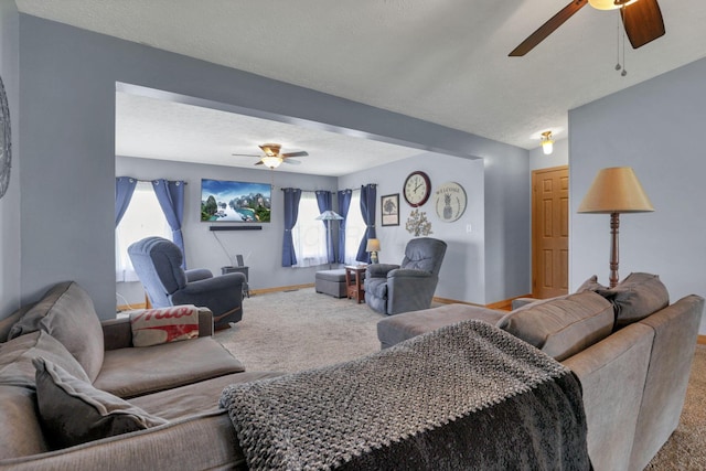living area with carpet floors, a textured ceiling, ceiling fan, and baseboards