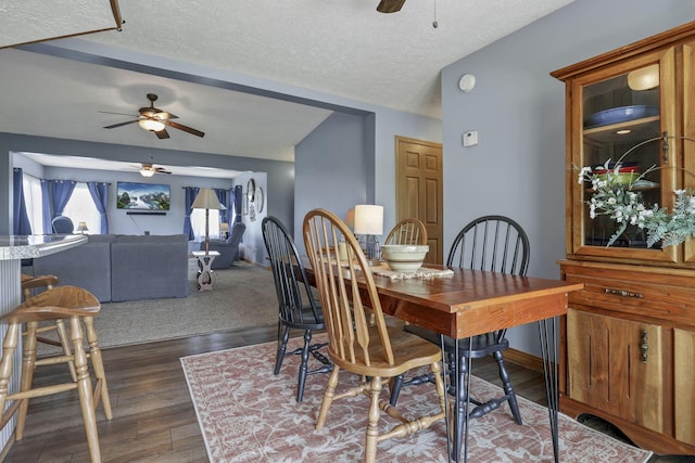 dining space featuring ceiling fan, dark wood-style flooring, and a textured ceiling