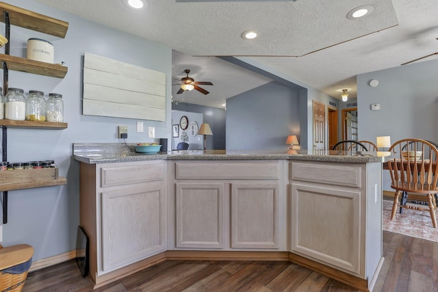 kitchen featuring open shelves, dark wood-style flooring, a peninsula, a textured ceiling, and a ceiling fan