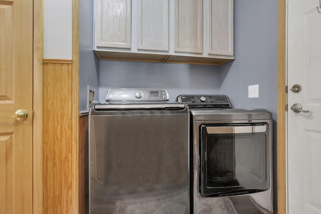 washroom featuring cabinet space and washing machine and clothes dryer