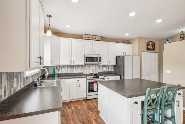 2128 Clay Stone Pl, Reynoldsburg, OH 43068 - kitchen with dark countertops, a sink, appliances with stainless steel finishes, and white cabinetry
