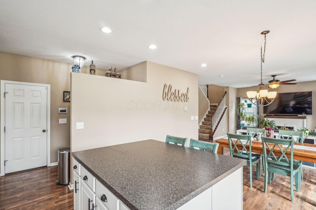 2128 Clay Stone Pl, Reynoldsburg, OH 43068 - kitchen featuring white cabinets, dark countertops, dark wood-style floors, an inviting chandelier, and hanging light fixtures