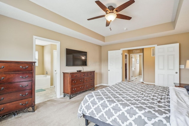 2128 Clay Stone Pl, Reynoldsburg, OH 43068 - bedroom with connected bathroom, ceiling fan, a tray ceiling, baseboards, and light colored carpet