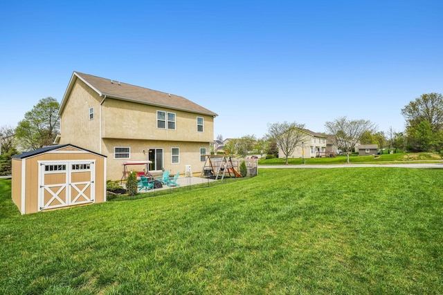 2128 Clay Stone Pl, Reynoldsburg, OH 43068 - back of house with a playground, an outbuilding, a storage shed, stucco siding, and a yard