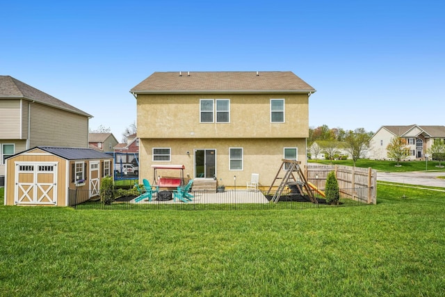 2128 Clay Stone Pl, Reynoldsburg, OH 43068 - rear view of house featuring an outdoor structure, a lawn, a storage unit, stucco siding, and fence
