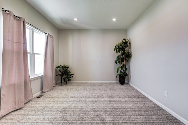 carpeted empty room with baseboards, visible vents, and recessed lighting