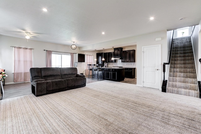 living area featuring recessed lighting, a healthy amount of sunlight, and stairs