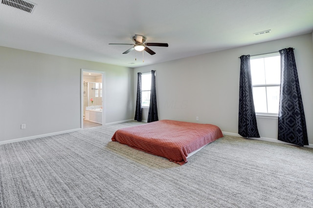 carpeted bedroom with visible vents, baseboards, and multiple windows