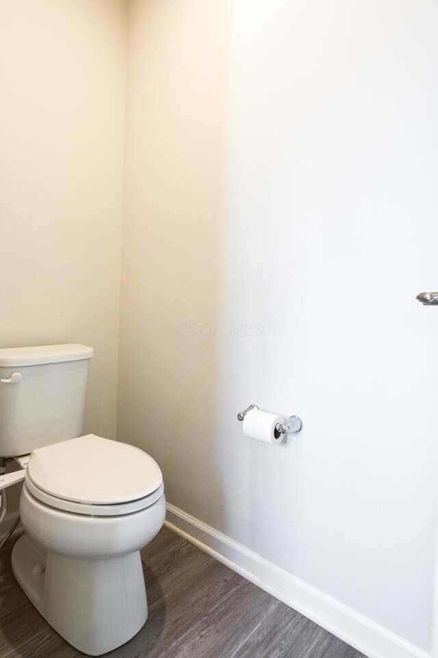 bathroom with wood finished floors, toilet, and baseboards