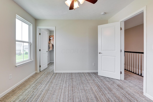 unfurnished bedroom featuring baseboards, carpet floors, and ceiling fan
