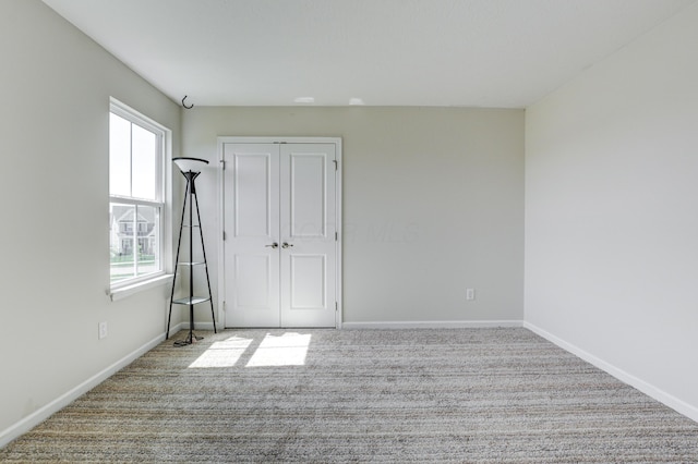 carpeted empty room with baseboards
