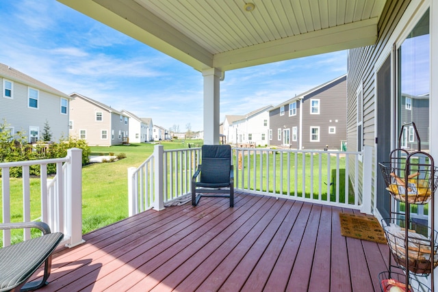 deck featuring a lawn and a residential view