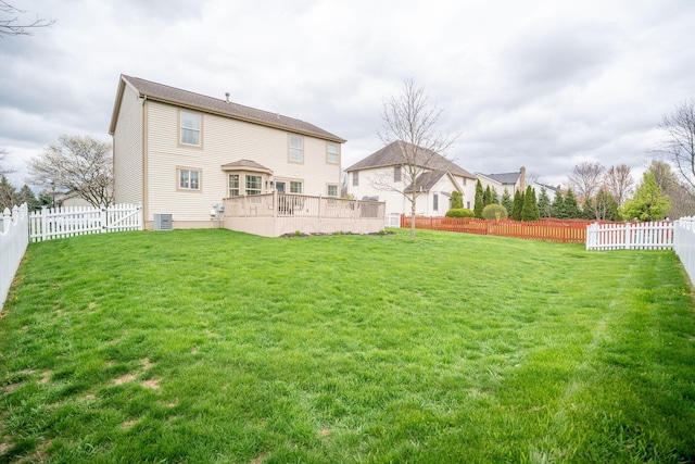 back of house featuring a fenced backyard, a yard, and a deck