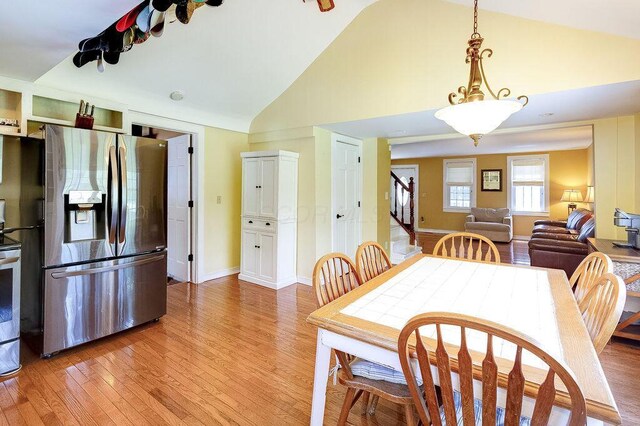 8028 Concord Rd, Johnstown, OH 43031 - dining area with stairway, light wood-type flooring, high vaulted ceiling, and baseboards