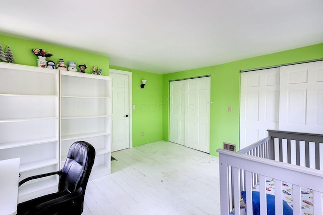 8028 Concord Rd, Johnstown, OH 43031 - unfurnished bedroom with multiple closets, wood finished floors, and a desk