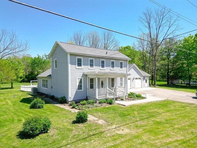 8028 Concord Rd, Johnstown, OH 43031 - colonial-style house with covered porch, cooling unit, a front yard, a garage, and a shingled roof