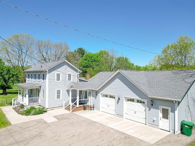8028 Concord Rd, Johnstown, OH 43031 - view of front of house featuring a garage, a porch, a shingled roof, and concrete driveway