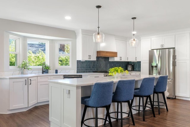 kitchen featuring a sink, custom range hood, dark wood-type flooring, a kitchen island, and stainless steel refrigerator with ice dispenser