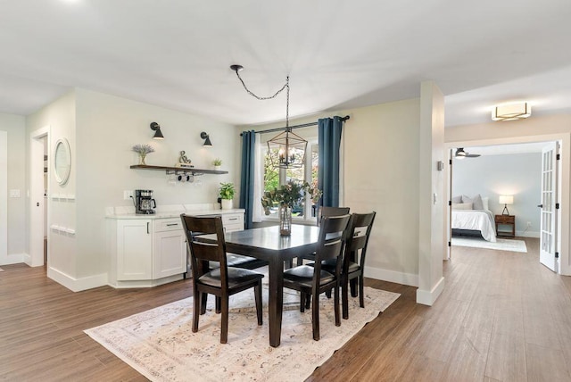 dining space with baseboards and wood finished floors