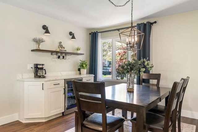 dining space featuring a dry bar, dark wood finished floors, beverage cooler, and a chandelier