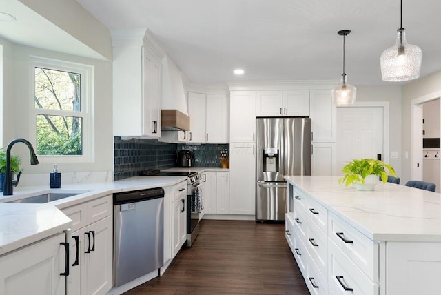 kitchen featuring light stone countertops, white cabinets, a sink, appliances with stainless steel finishes, and backsplash