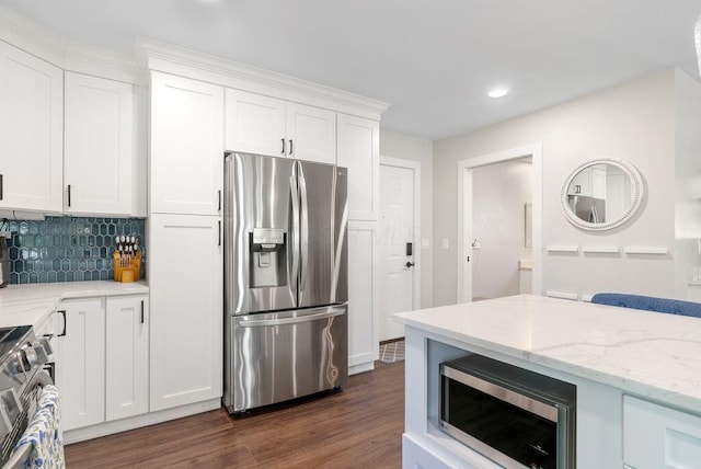 kitchen featuring decorative backsplash, dark wood-style flooring, white cabinetry, light stone counters, and appliances with stainless steel finishes