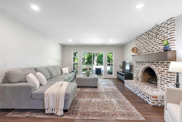 living room with recessed lighting, a fireplace, and dark wood-style floors