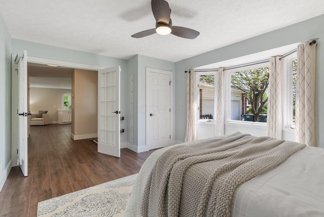 bedroom with baseboards, ceiling fan, a closet, and wood finished floors
