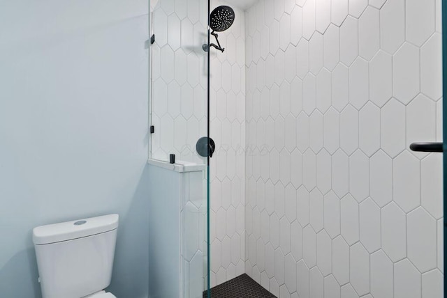 bathroom featuring a stall shower and toilet