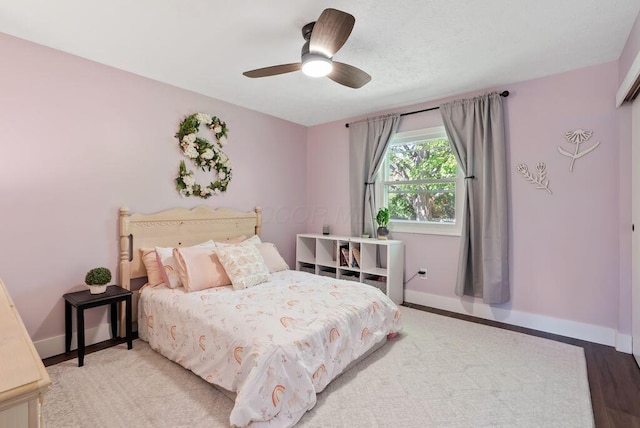 bedroom with baseboards, ceiling fan, and wood finished floors