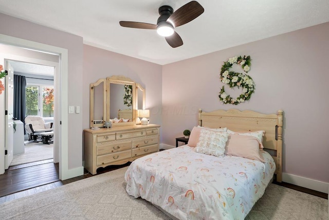bedroom featuring baseboards, ceiling fan, and wood finished floors