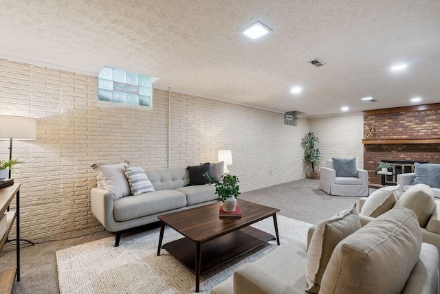 carpeted living area with visible vents, recessed lighting, a textured ceiling, and a fireplace