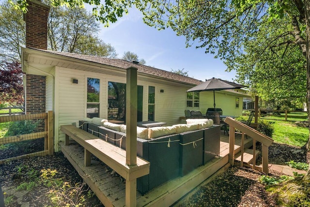 rear view of house featuring a wooden deck, a chimney, and an outdoor living space