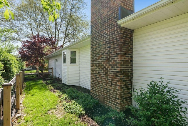 view of home's exterior featuring fence and brick siding