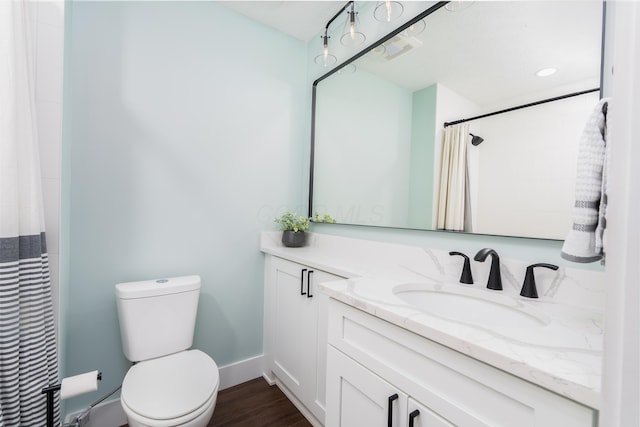 bathroom with visible vents, curtained shower, wood finished floors, vanity, and toilet