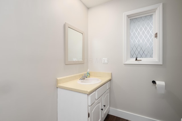 bathroom with baseboards, wood finished floors, and vanity