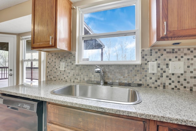 577 Stable St, Pataskala, OH 43062 - kitchen with a sink, dishwasher, a wealth of natural light, brown cabinetry, and backsplash