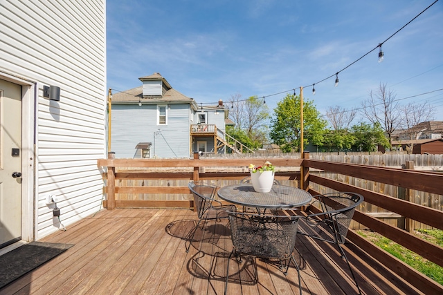 wooden terrace featuring outdoor dining space and fence