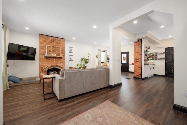 living area with a brick fireplace, dark wood-style floors, and recessed lighting