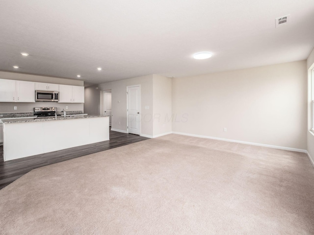 unfurnished living room featuring recessed lighting, dark colored carpet, visible vents, and baseboards