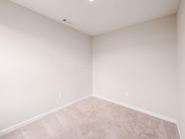 carpeted empty room featuring visible vents and baseboards