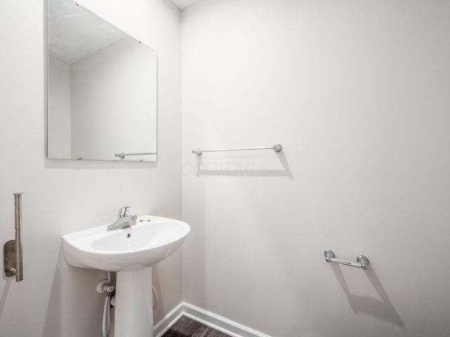 bathroom with wood finished floors and baseboards
