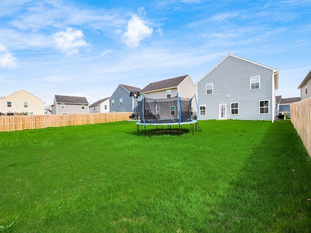 exterior space with fence, a residential view, and a trampoline