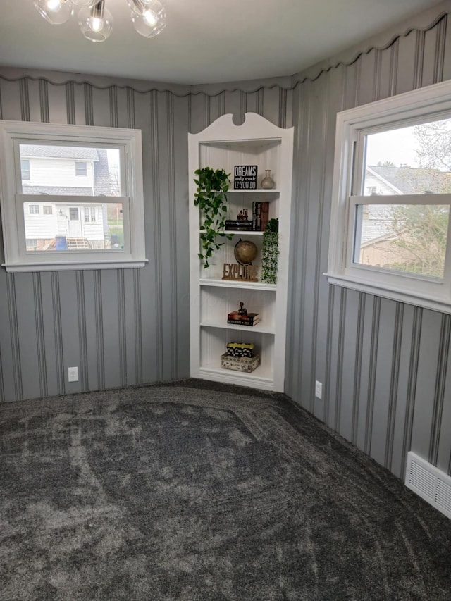 carpeted spare room featuring wallpapered walls and visible vents
