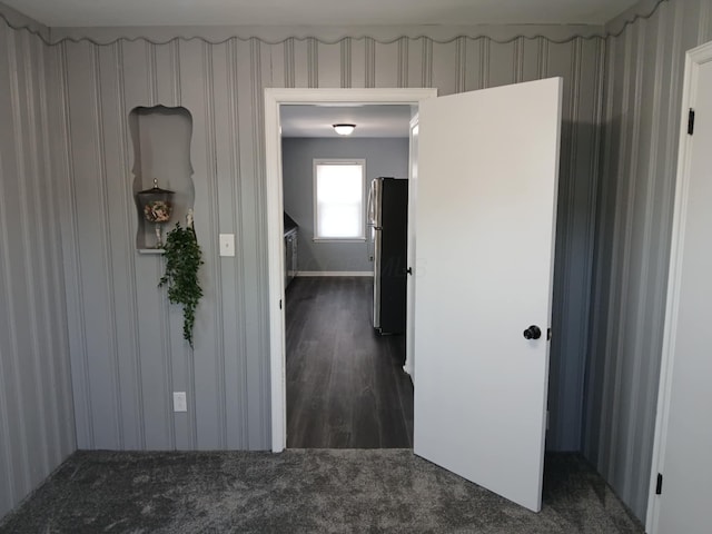 hall featuring dark colored carpet