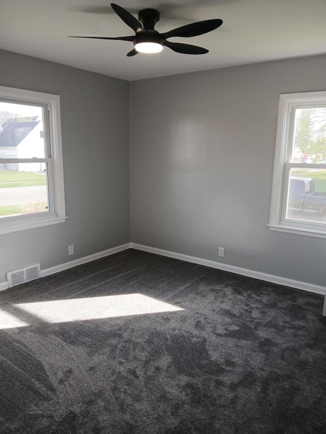spare room with baseboards, visible vents, carpet floors, and ceiling fan