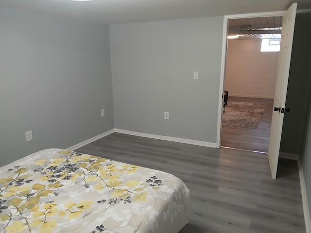 bedroom featuring baseboards and dark wood-style flooring